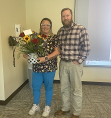 Photo of Andrew Knust presenting flower to Ann Stevens