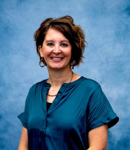 Headshot of Maria in blue dress shirt