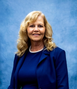 Headshot of Jackie in blue dress with blazer