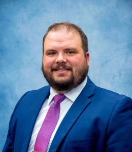 Brennon Malcom in a blue blazer with a light blue shirt and pink tie