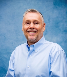 Mick Brant in a light blue button-down dress shirt