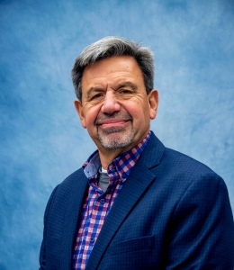 Karl Randecker in a blue blazer with pink and blue checked button-down shirt