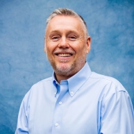 Mick Brant in a light blue button-down dress shirt